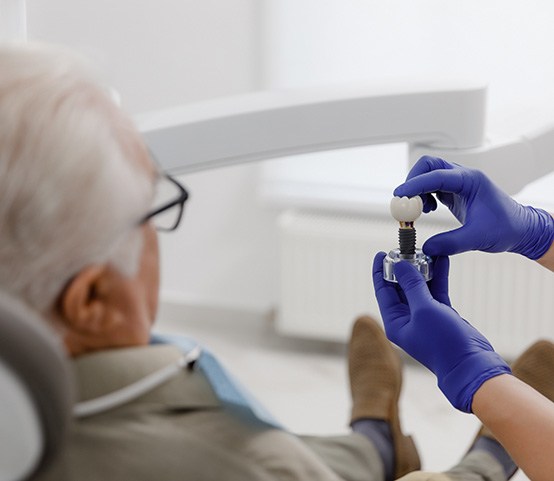 Palm Coast patient looking at a model of dental implants