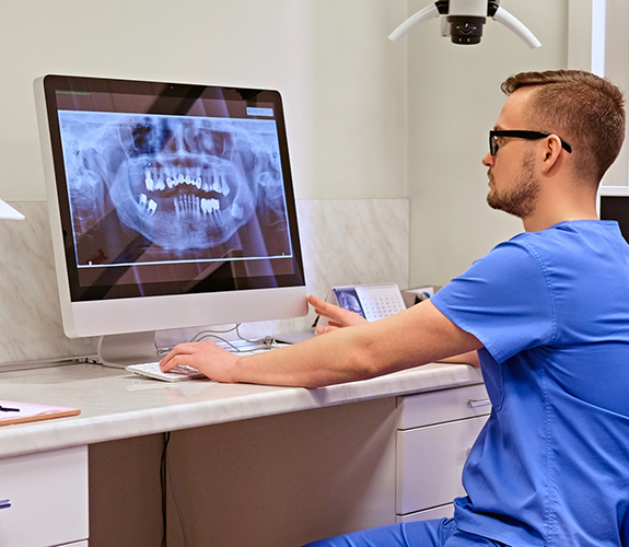 Dentist looking at X-ray on computer monitor