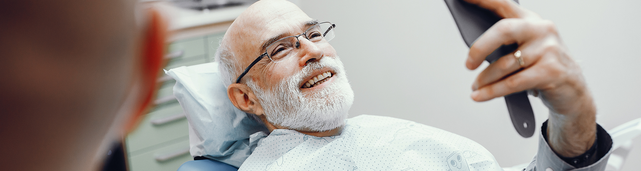 Bearded man in dental chair looking up and smiling