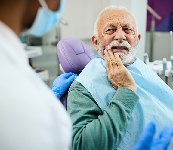 Senior man in dental chair with toothache visiting emergency dentist in Palm Coast