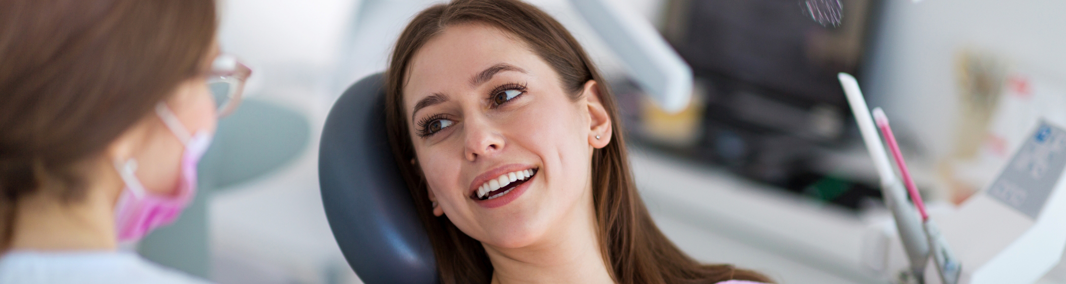 Woman with brown hair smiling in dental chair