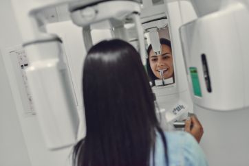 Woman about to have teeth scanned with CBCT scanner