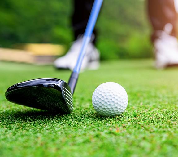 Close-up of golf club about to hit golf ball