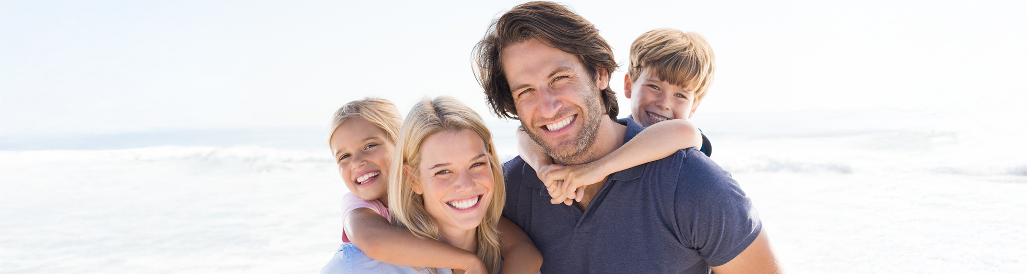 Man and woman giving children piggyback rides